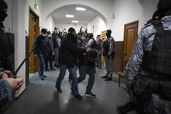 Doi suspecti in cazul atacului din Moscova, adusi la tribunal si inculpati. Amandoi au ochii invinetiti. Imagini cu ei pe banca acuzatilor