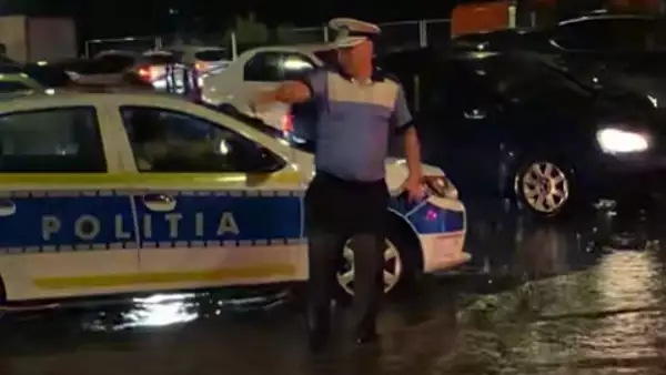 Eroul in uniforma albastra care a dirijat traficul in timpul furtunii. A stat cu apa pana la genunchi in mijlocul intersectiei - VIDEO