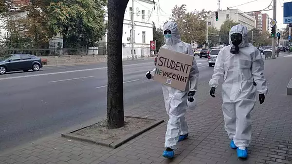 Imaginea MOMENTULUI! Doi studenti din Iasi protesteaza impotriva vaccinarii anti-Covid-19 imbracati in combinezoane