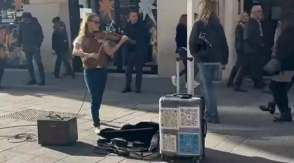 O tanara romanca face senzatie cu vioara pe strazile din Italia. Imaginile au devenit virale pe internet